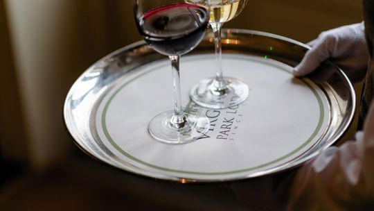 waiter carrying red and white wine on a tray at Virginia Park Lodge