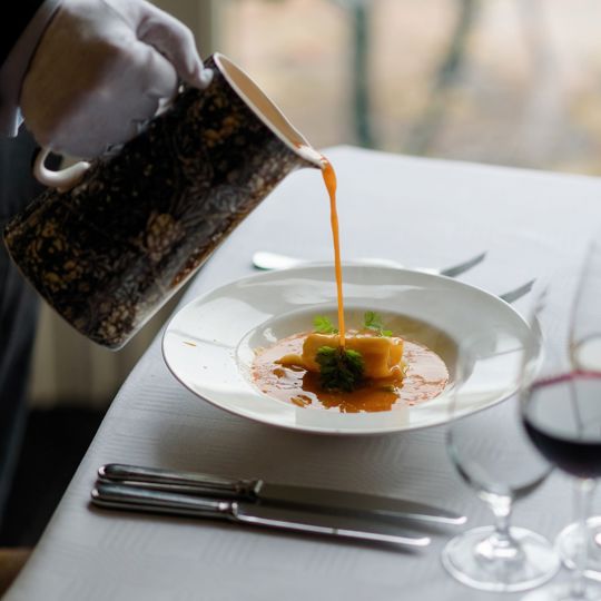 waiter pouring gravy on a plate of food at Virginia Park Lodge